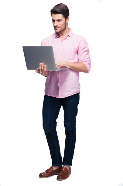 Young man standing and using laptop - Φωτογραφία, εικόνα