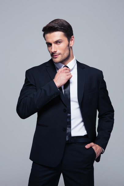 Handsome businessman straightening his tie - Фото, изображение