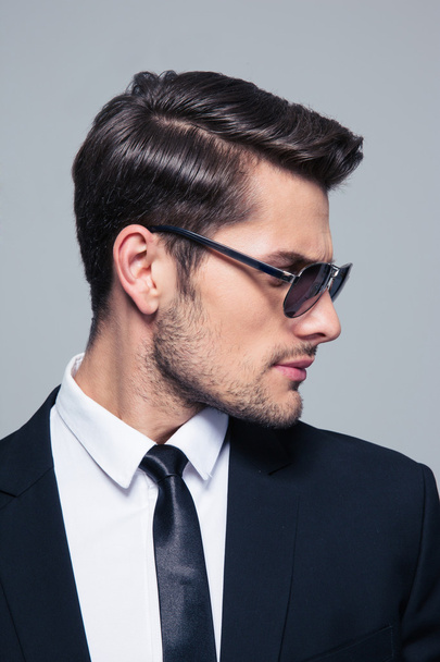 Businessman in sunglasses looking away - Fotó, kép