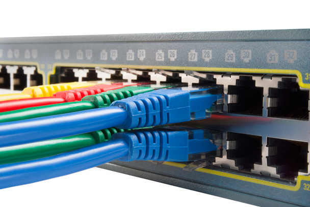 Многоцветные сетевые кабели, подключенные к изолированному коммутатору
 - Фото, изображение