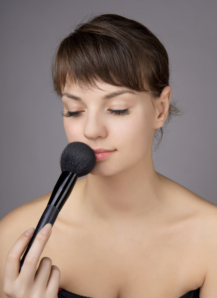 Beautiful girl who does make-up brush - Foto, afbeelding