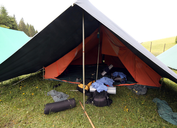 バックパックと寝袋が付いているボーイ・スカウト キャンプのテントを広める o - 写真・画像