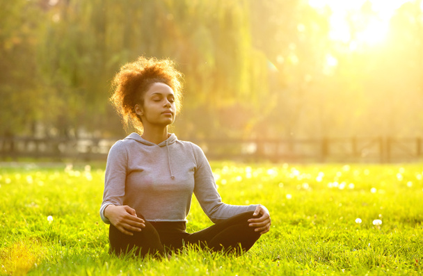 アフリカ系アメリカ人の女性が自然に瞑想  - 写真・画像