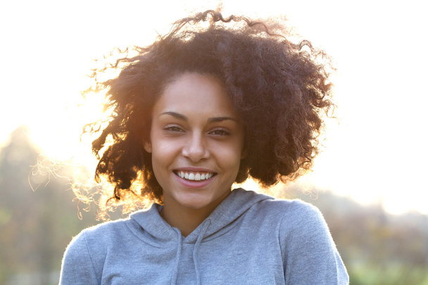 巻き毛を持つ幸せな笑顔の若い女性 - 写真・画像