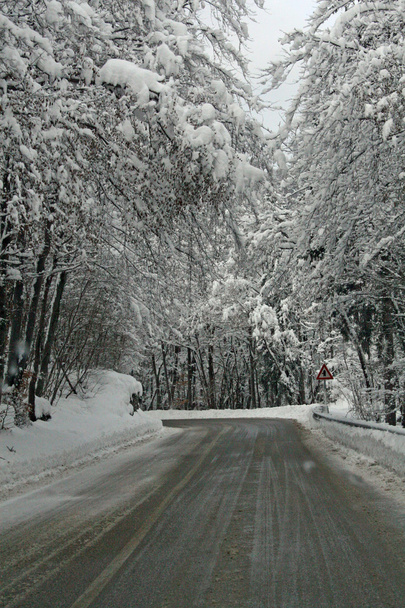 επικίνδυνο παγωμένο δρόμο χειμώνα με χιόνια στα βουνά για τη διαμετακόμιση - Φωτογραφία, εικόνα