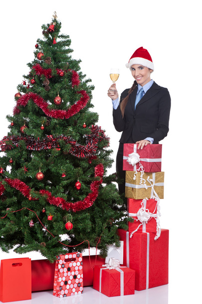 Woman drink a champagne in front of a christmas tree - Fotó, kép
