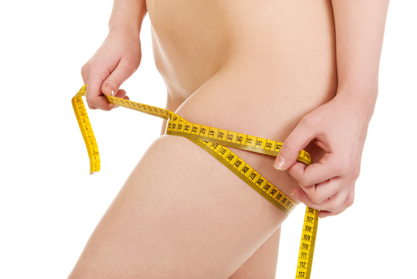 Slim woman measuring her thigh. - Valokuva, kuva