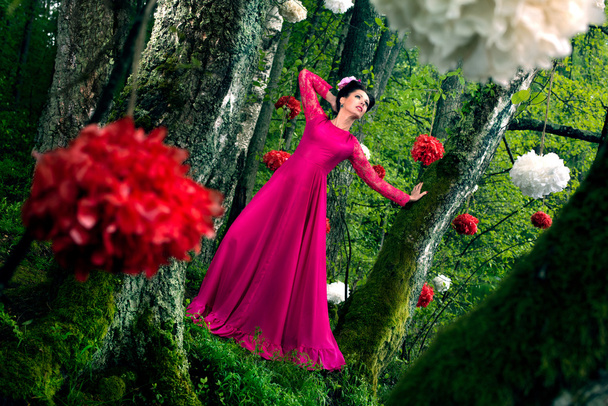 woman in long pink dress in the wood - Fotó, kép