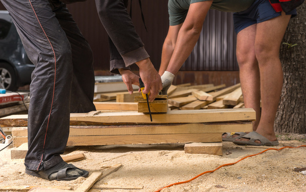 Arbeiter auf der Baustelle schneiden Holzbohlen - Foto, Bild