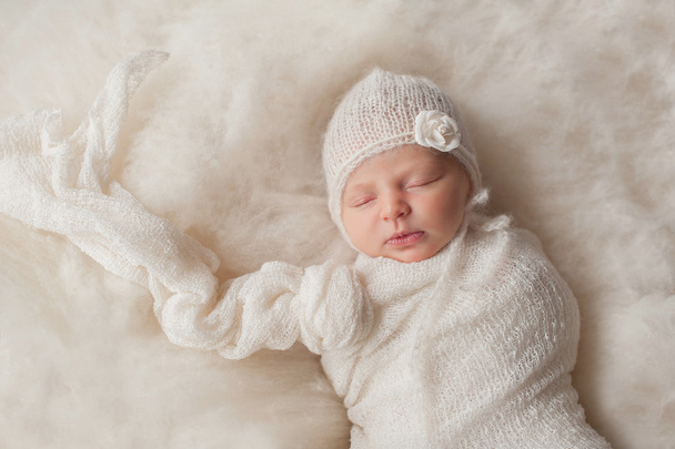 Pasgeboren babymeisje in gebreide Bonnet - Foto, afbeelding