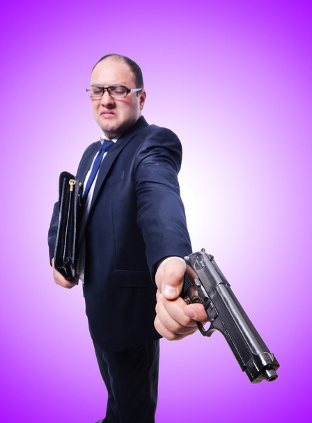 Businessman with gun against the gradient - Photo, image