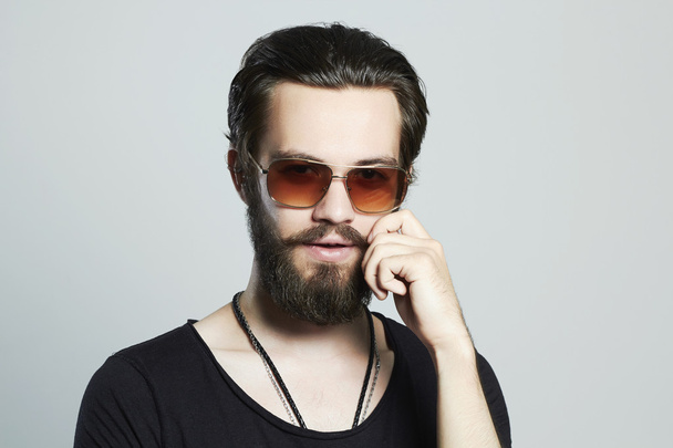 fashionable handsome man. Brutal bearded Sexy boy in trendy sunglasses - Photo, Image