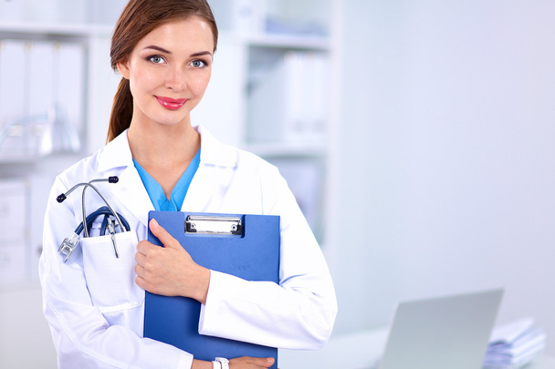Mosolygó női orvos egy mappa egyenruha áll a kórházban - Fotó, kép