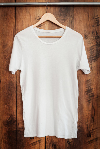 white T-shirt hanging on hanger - Foto, imagen