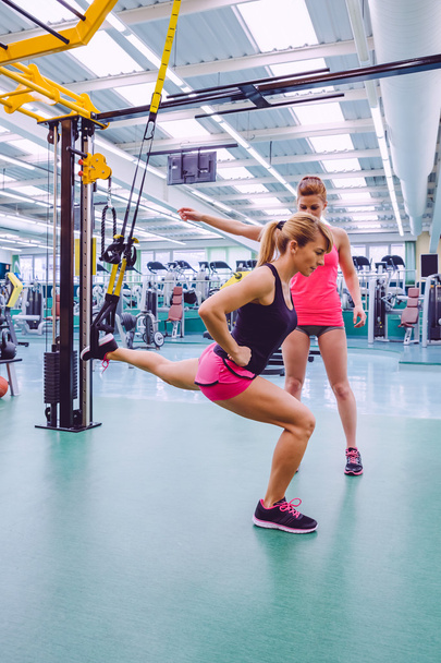 Personal trainer teaching to woman in suspension training - Zdjęcie, obraz