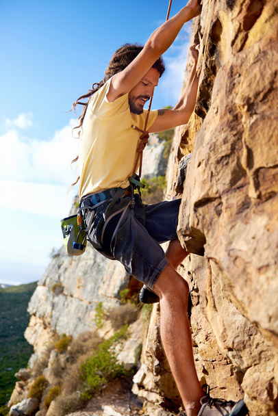 rockclimbing guy finding foothold on mountain - Photo, Image