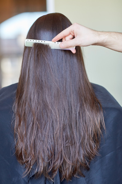 hand with comb combing woman hair at salon - Photo, Image