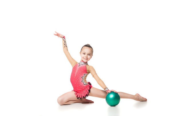 pretty little girl doing gymnastics with a ball over white background - Zdjęcie, obraz