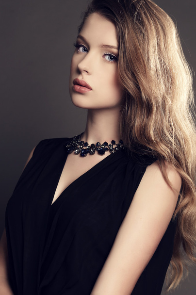 beautiful young girl in elegant black dress with bijou   - Фото, зображення