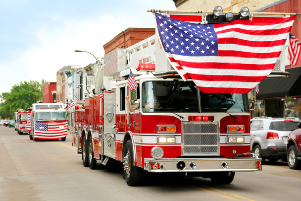 Feuerwehrfahrzeuge mit amerikanischen Flaggen bei Kleinstadt-Parade - Foto, Bild