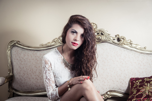 Pretty model girl sitting on victorian sofa posing for camera - Φωτογραφία, εικόνα