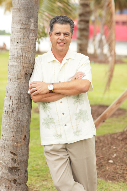 Hombre apoyado en una palmera
 - Foto, imagen