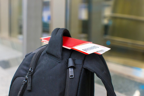 Pasaportes de primer plano y tarjeta de embarque en mochila en el aeropuerto
 - Foto, Imagen
