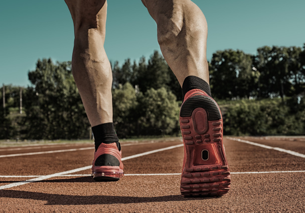 Atletische man beginnen avond joggen in zonnestralen - Foto, afbeelding