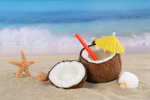 Coconut fruit cocktail drink in summer on the beach and sea - Photo, image