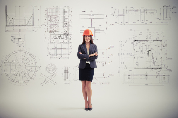 woman in hardhat over grey wall with prints - Photo, Image