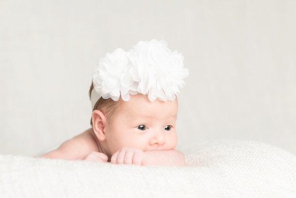 Πορτρέτο του νεογέννητο κοριτσάκι με λευκή κορδέλα  - Φωτογραφία, εικόνα