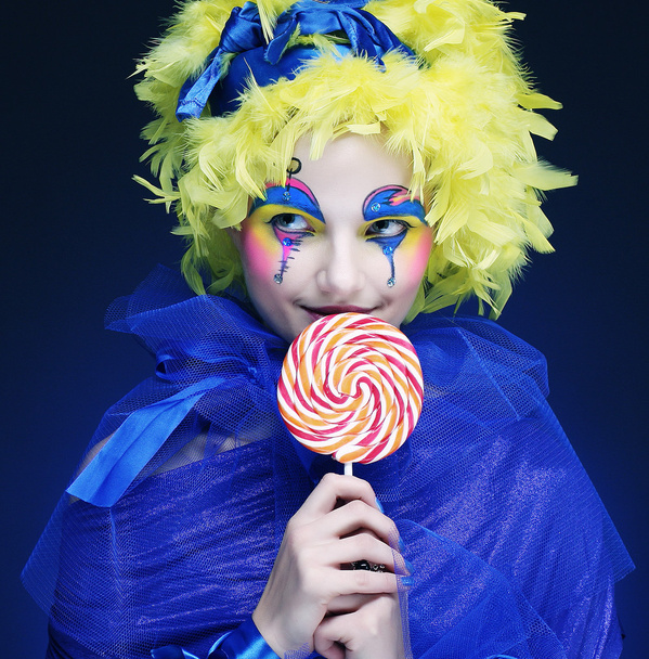 Girl with with creative make-up holds lollipop - Foto, Imagen