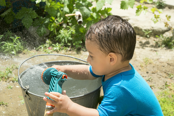 ein Junge spielt mit Wasser - Foto, Bild