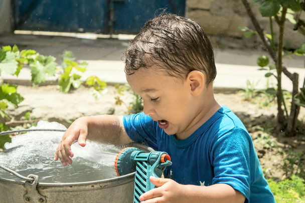 un garçon joue avec l'eau
 - Photo, image