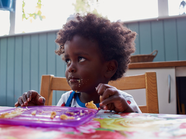 Adorable black African baby eating - Photo, Image