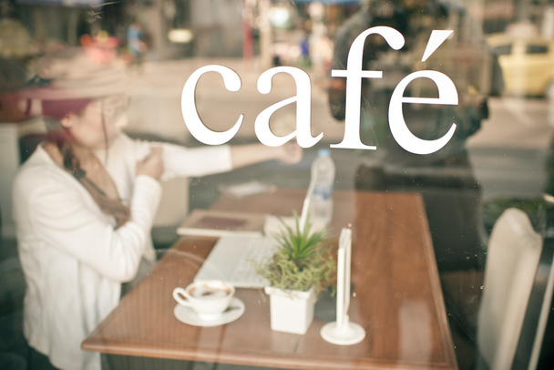 Cafe with Asian woman drinking coffee background. - Фото, зображення