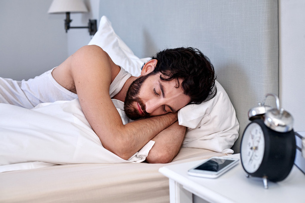 man sleeping comfortably in bed - Photo, Image