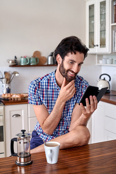 Man enjoying coffee with cellphone at home - 写真・画像