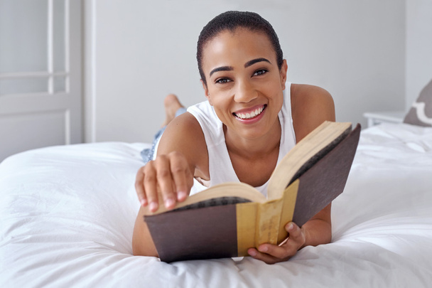 woman laying on bed reading book - Photo, Image