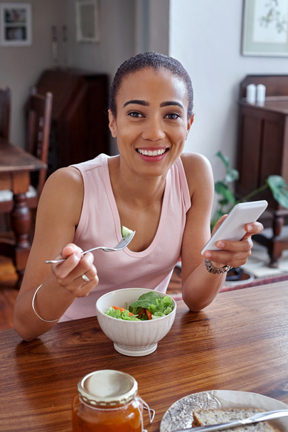 woman enjoying salad with cellphone - Foto, Imagem