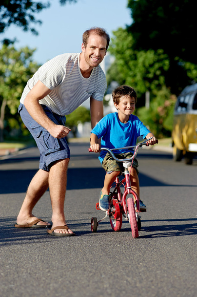 Pai ensinando filho aprendendo a andar de bicicleta
 - Foto, Imagem