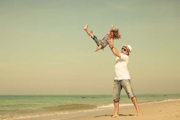Ojciec i syn, gry na plaży w czasie dnia. - Zdjęcie, obraz