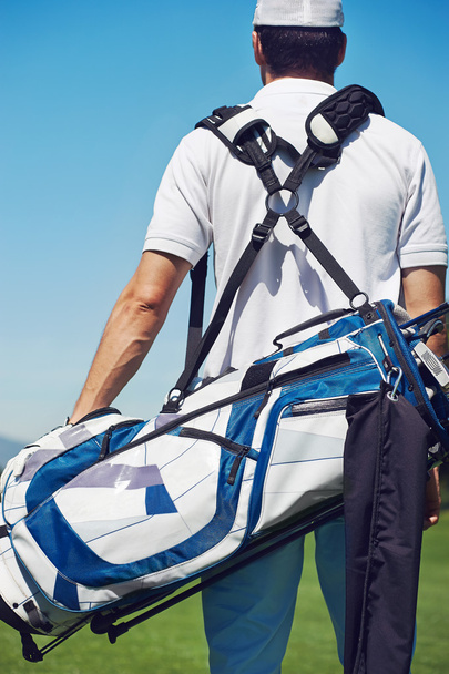 Jugador de golf caminando y llevando bolsa
 - Foto, imagen