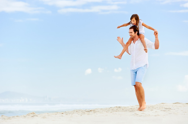 padre con hija caminando en la playa
 - Foto, Imagen