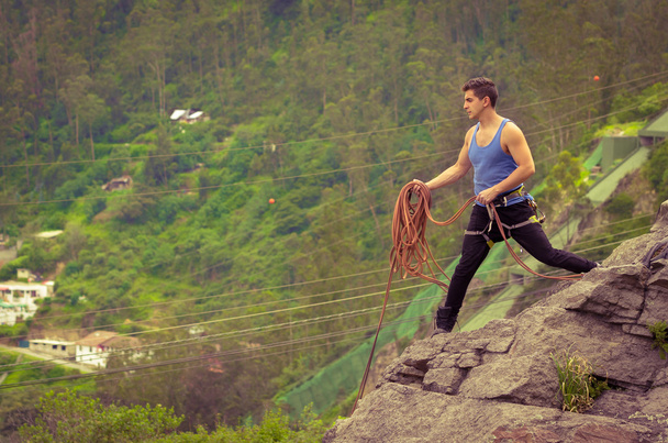 hombre atlético de pie en el acantilado con la cuerda en las manos
 - Foto, imagen