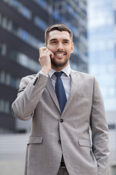 smiling businessman with smartphone outdoors - Zdjęcie, obraz