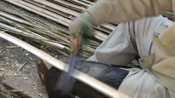 Рабочий режет кусочки бамбука
. - Кадры, видео