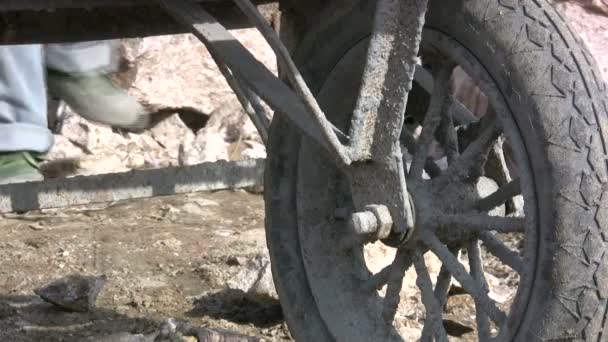 Feet of worker behind a wheelbarrow - Footage, Video
