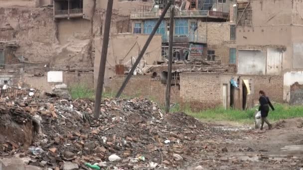 Mujer camina a casa a través de un demolido
 - Imágenes, Vídeo