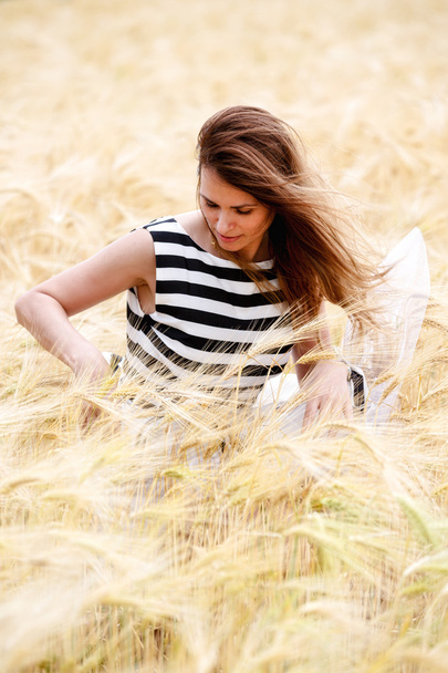 gorgeous girl walking in the field of long grass and dragging he - 写真・画像